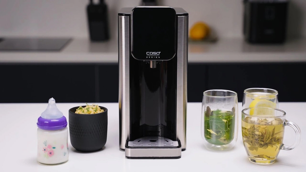 Wasserkocher mit Getränken, Babyflasche und Essen auf dem Tisch