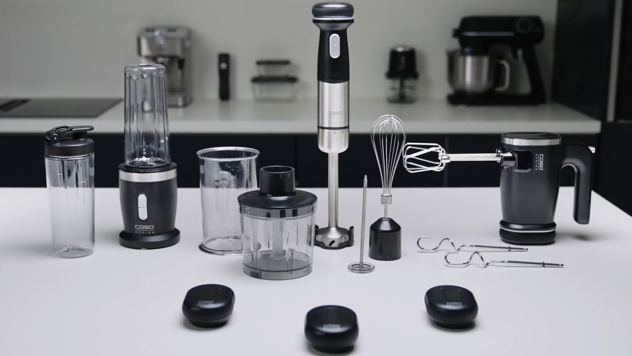 Küchengeräte auf weißem Tisch: Mixer, Stabmixer, Schneebesen, Handmixer, Zubehör.