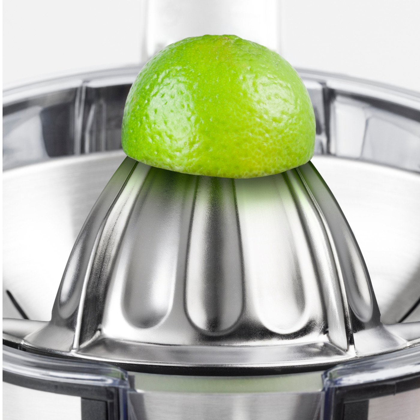 Nahaufnahme einer Limette auf einer Zitruspresse aus Metall