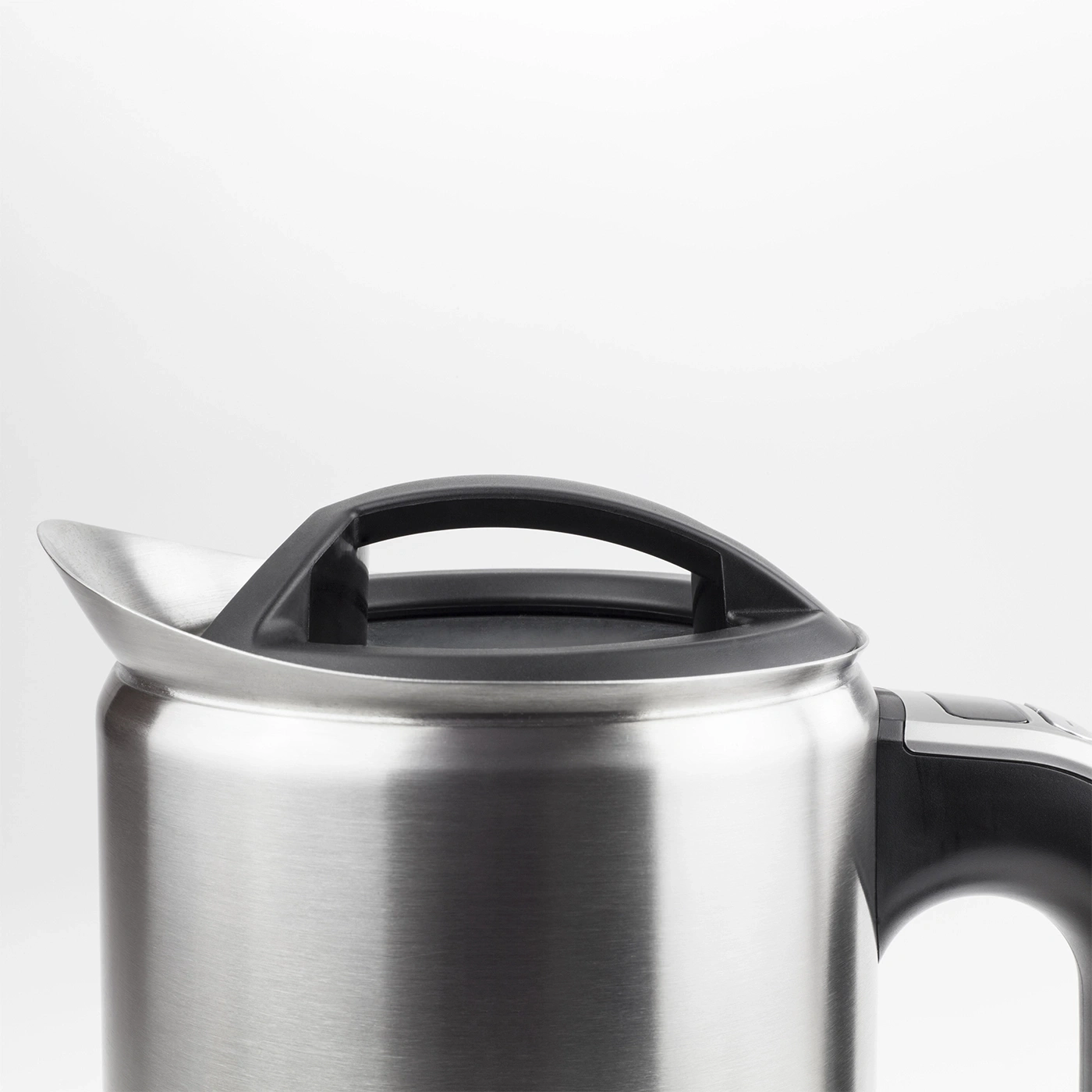 Nahaufnahme eines silbernen Wasserkochers mit schwarzem Griff und Deckel