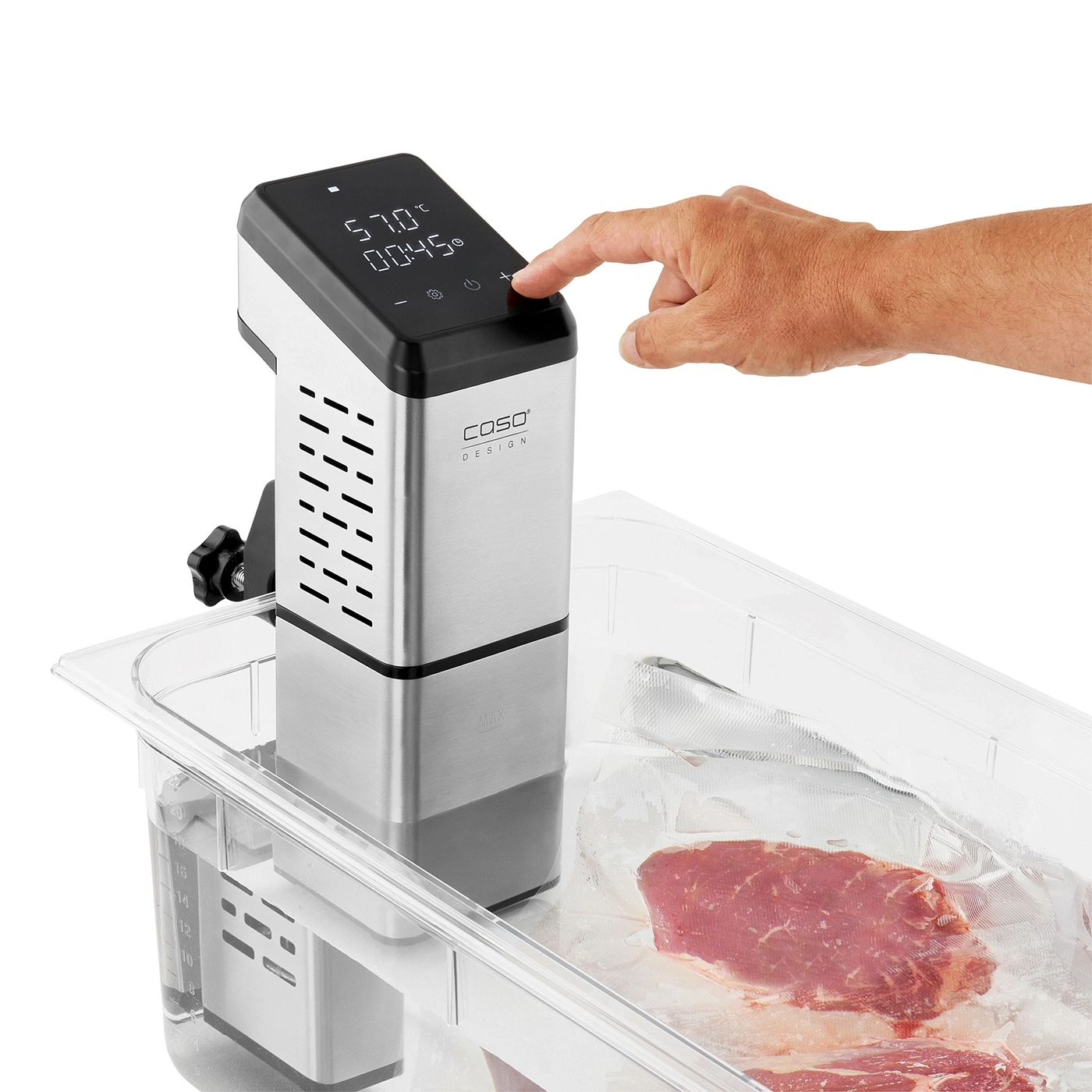 Sous vide cooker with meat in a plastic bag, being operated by a hand.