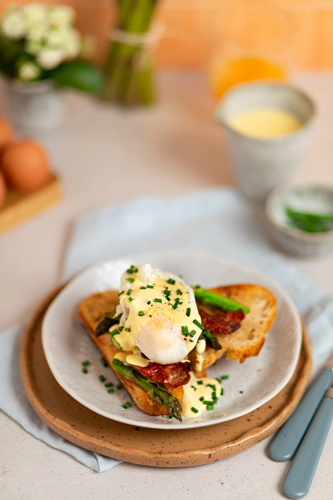Ein pochiertes Ei mit Sauce Hollandaise auf Toast mit Spargel und Speck.