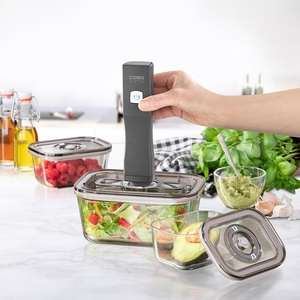 Vacuum sealer with containers, vegetables, fruits and avocado on marble table