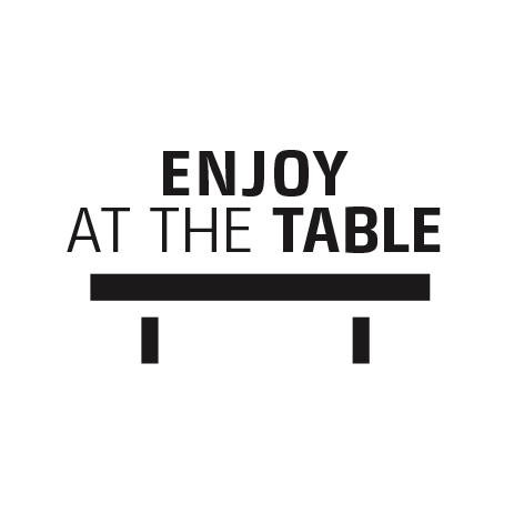 Enjoy at the table. Black background with text and table illustration.