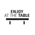 Enjoy at the table. Black background with text and table illustration.