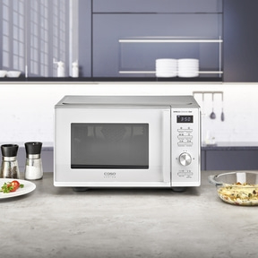 White microwave oven with control panel and display on a kitchen countertop.