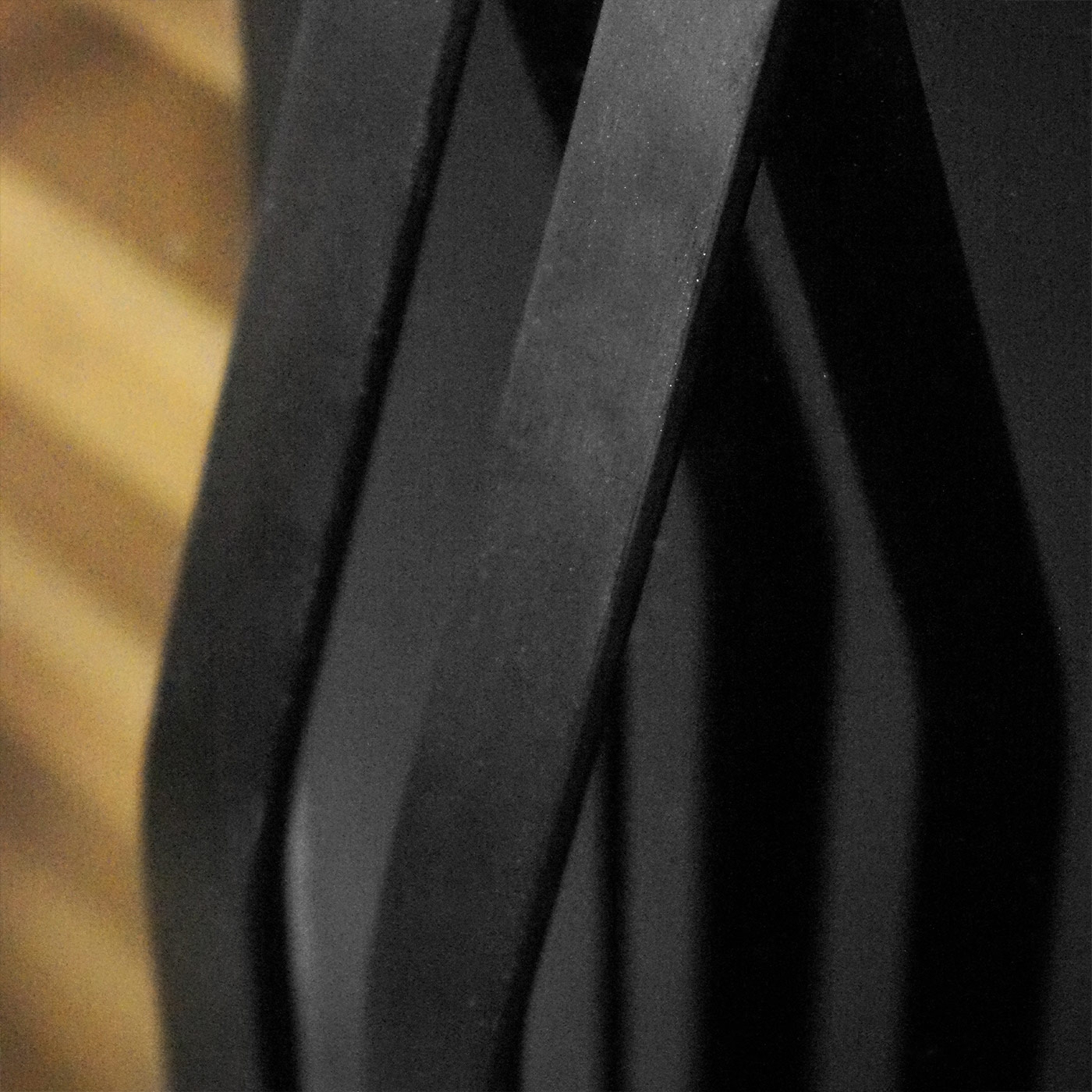 Abstract black metal strips against a wooden background, curved