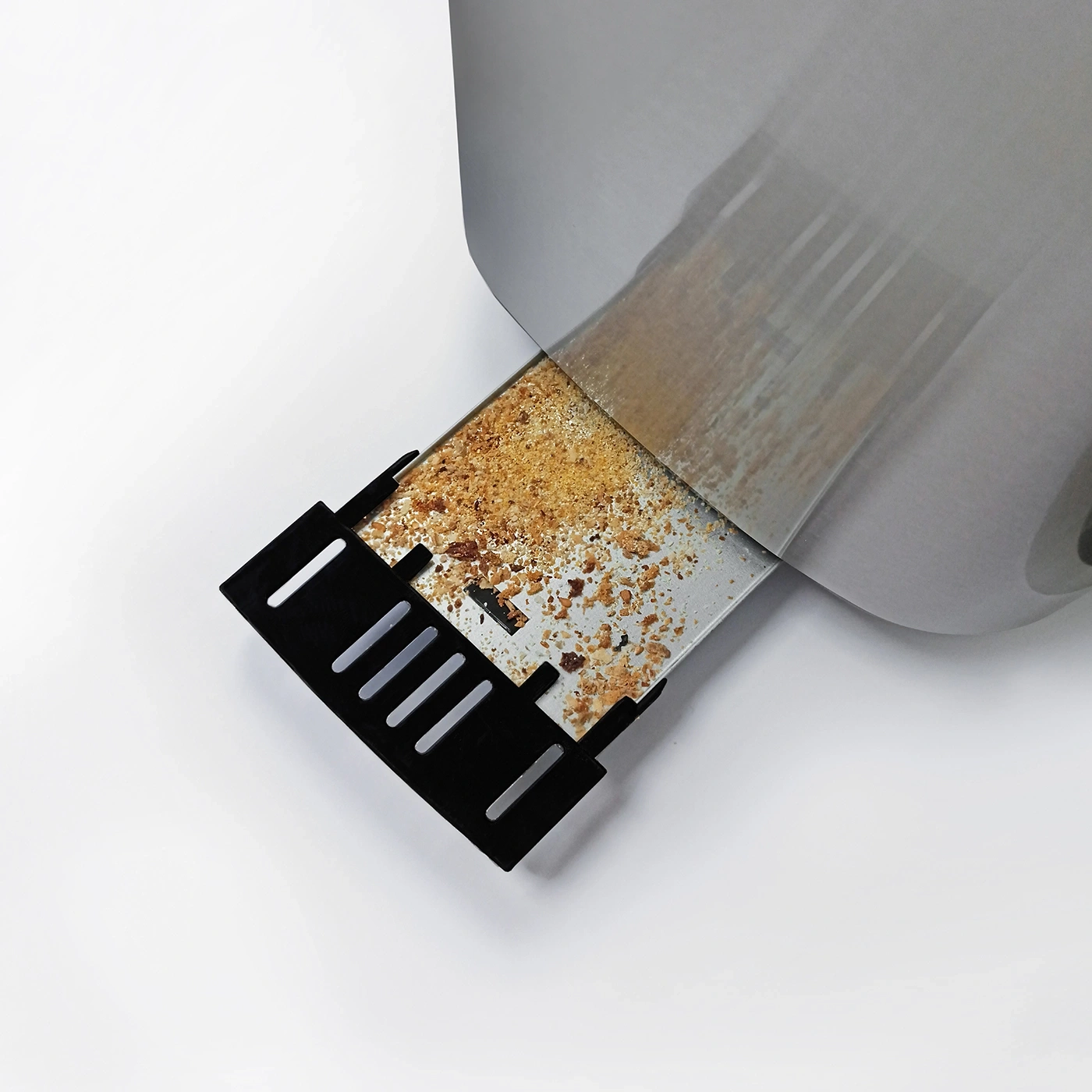 Close-up of a toaster with crumbs and a black crumb catcher, on white background.