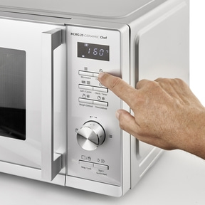 Microwave oven with control panel, hand pressing button, temperature display 160 degrees Celsius.