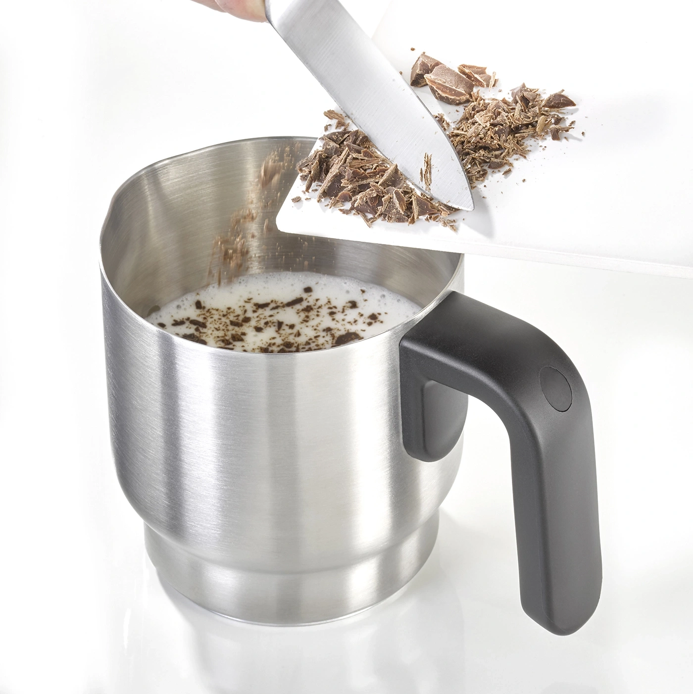 Chocolate being added to milk in a cup to make a drink, preparation process.