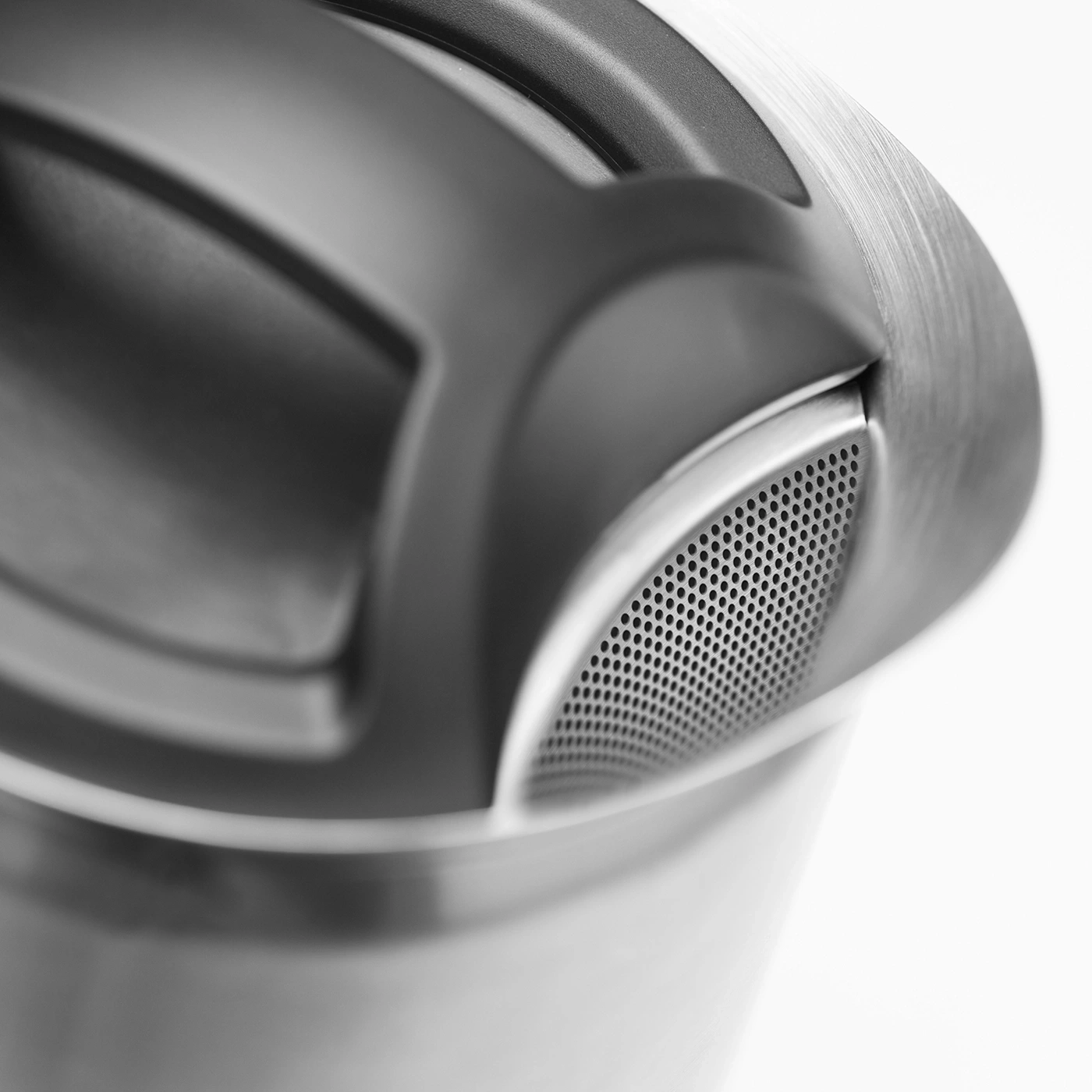 Nahaufnahme eines Metallteils mit Löchern und einem Griff, grau und weiß.