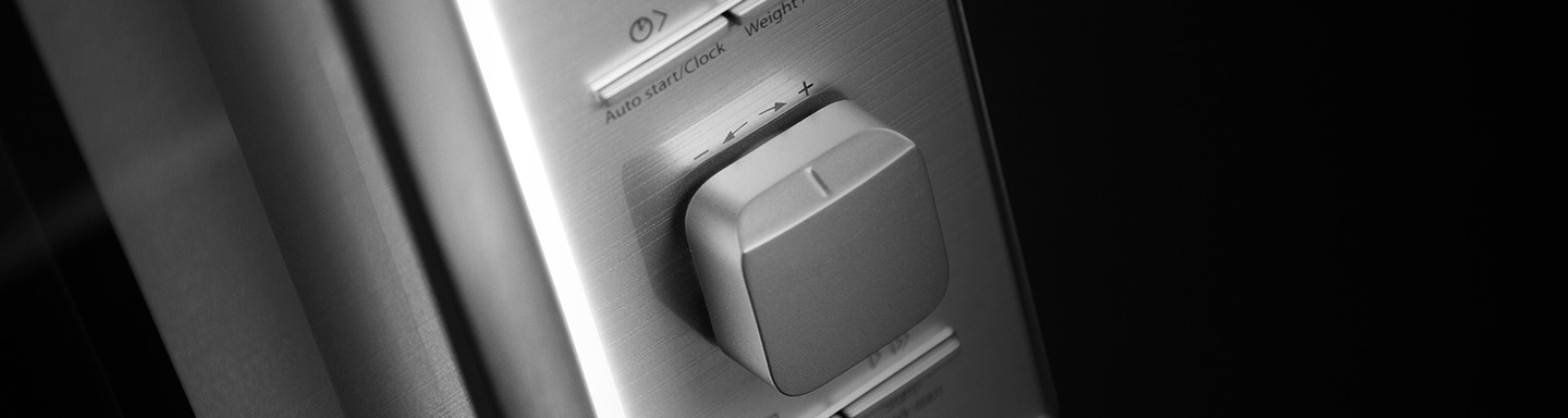 Close-up of a microwave control panel with a knob and buttons