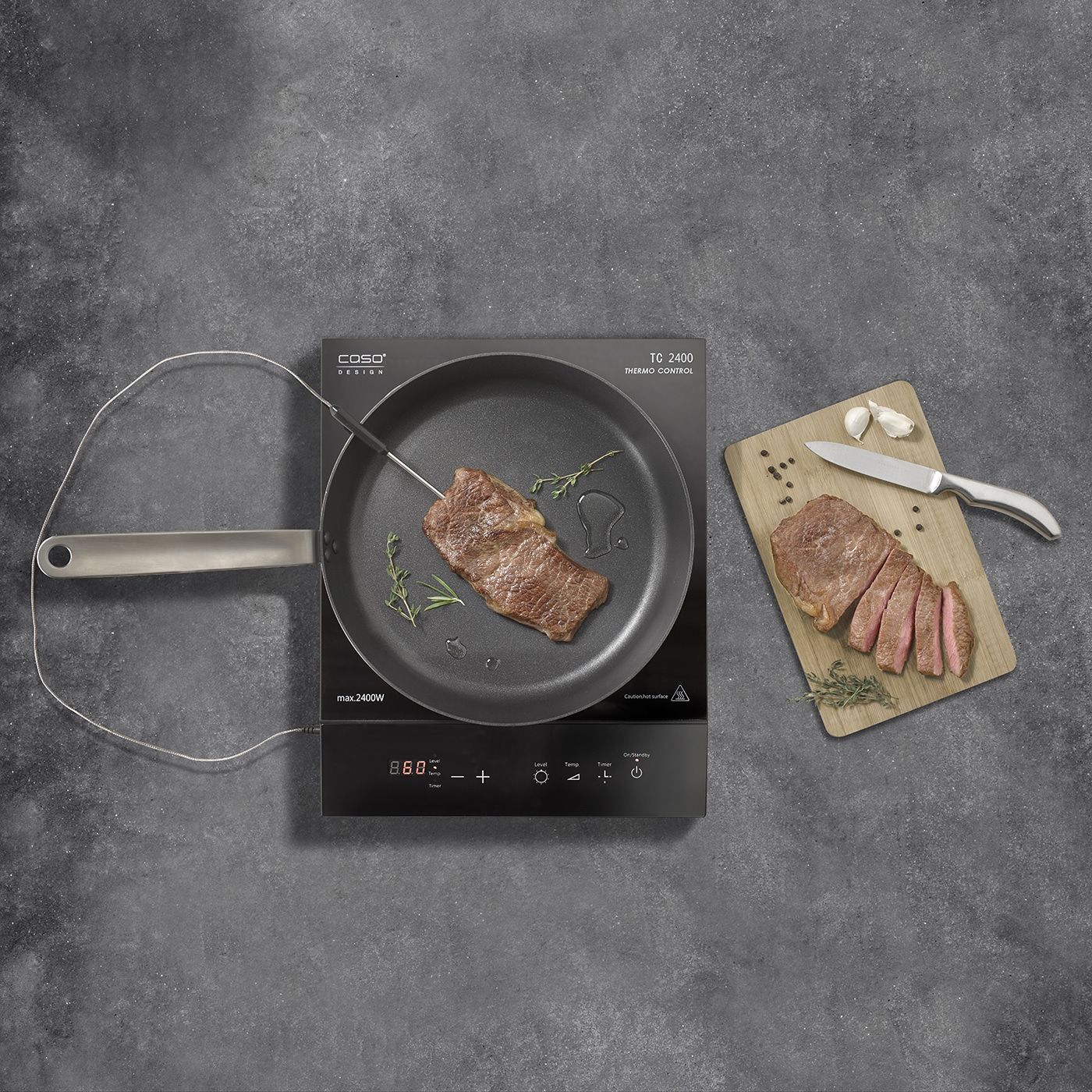 Steak in der Pfanne, auf dem Schneidebrett, mit Knoblauch und Kräutern