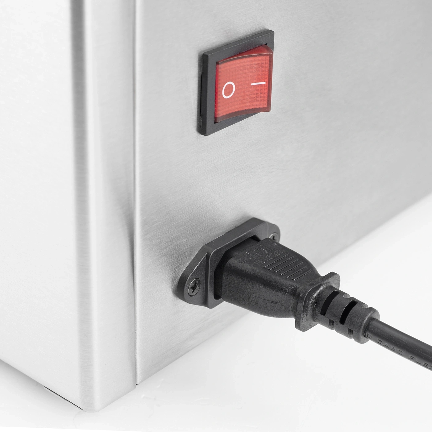 A red power switch and a black power cord on a metal casing.