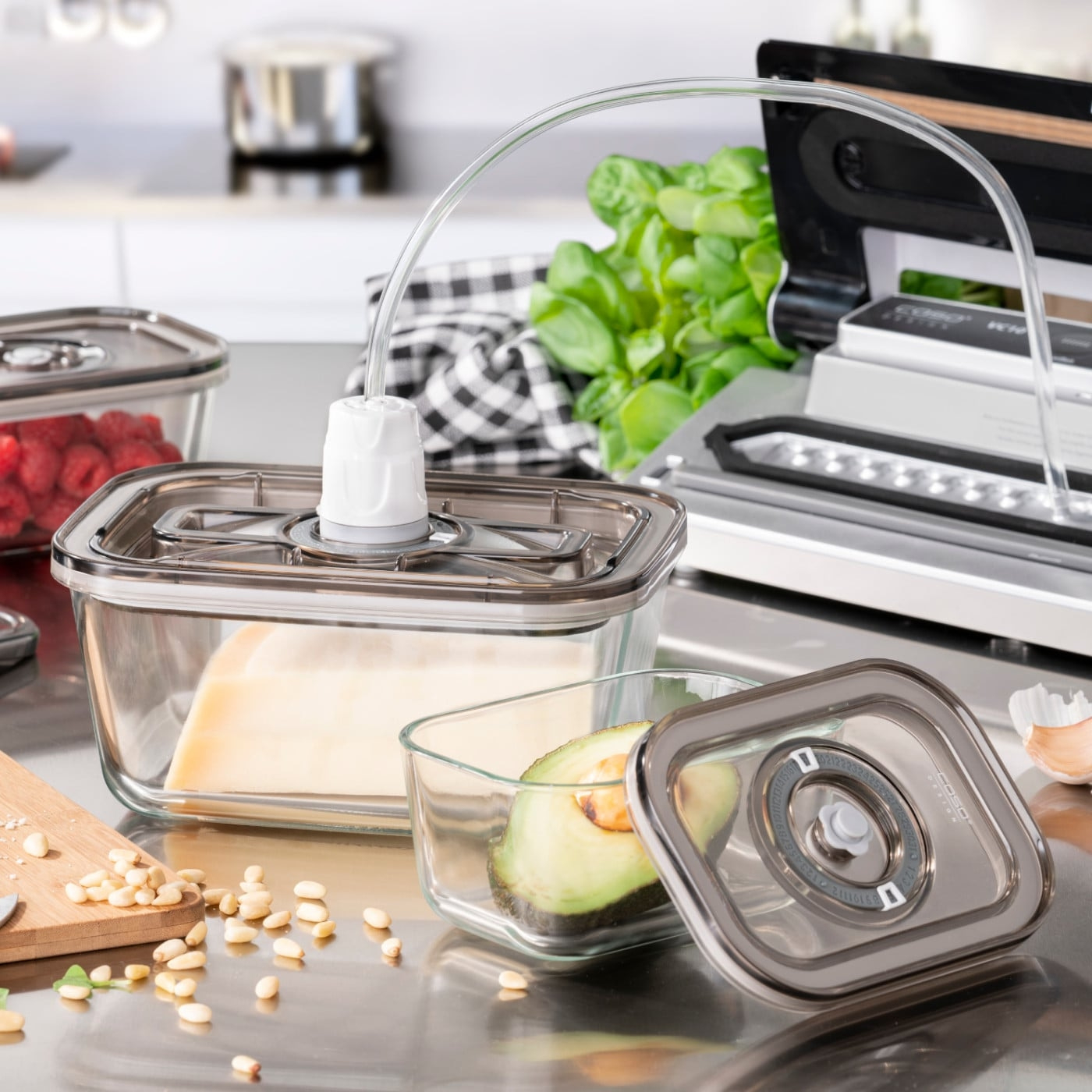 Vacuum sealer with containers, avocado, cheese, raspberries, pine nuts, kitchen, stainless steel
