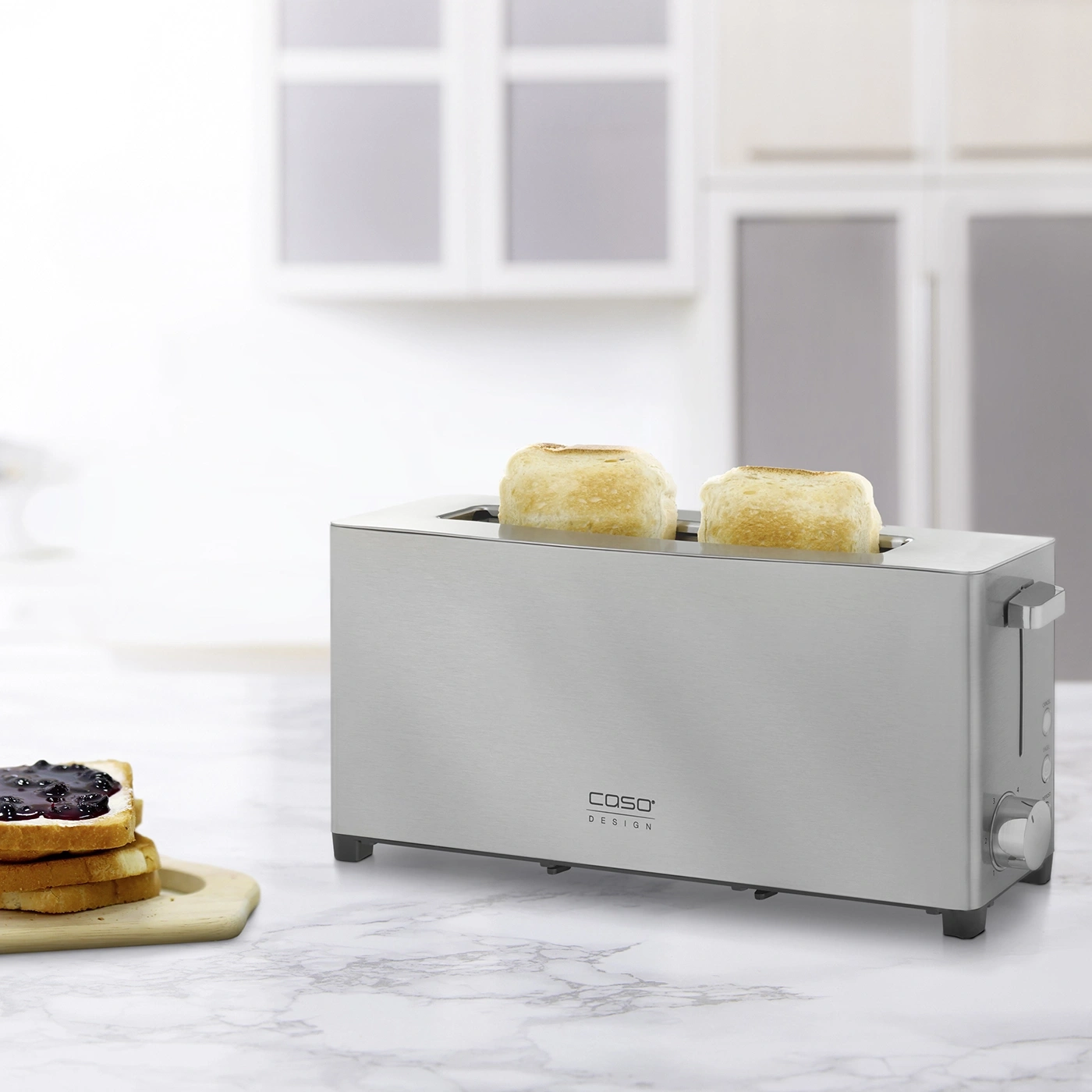 A toaster with two slices of toast, next to toast with jam.