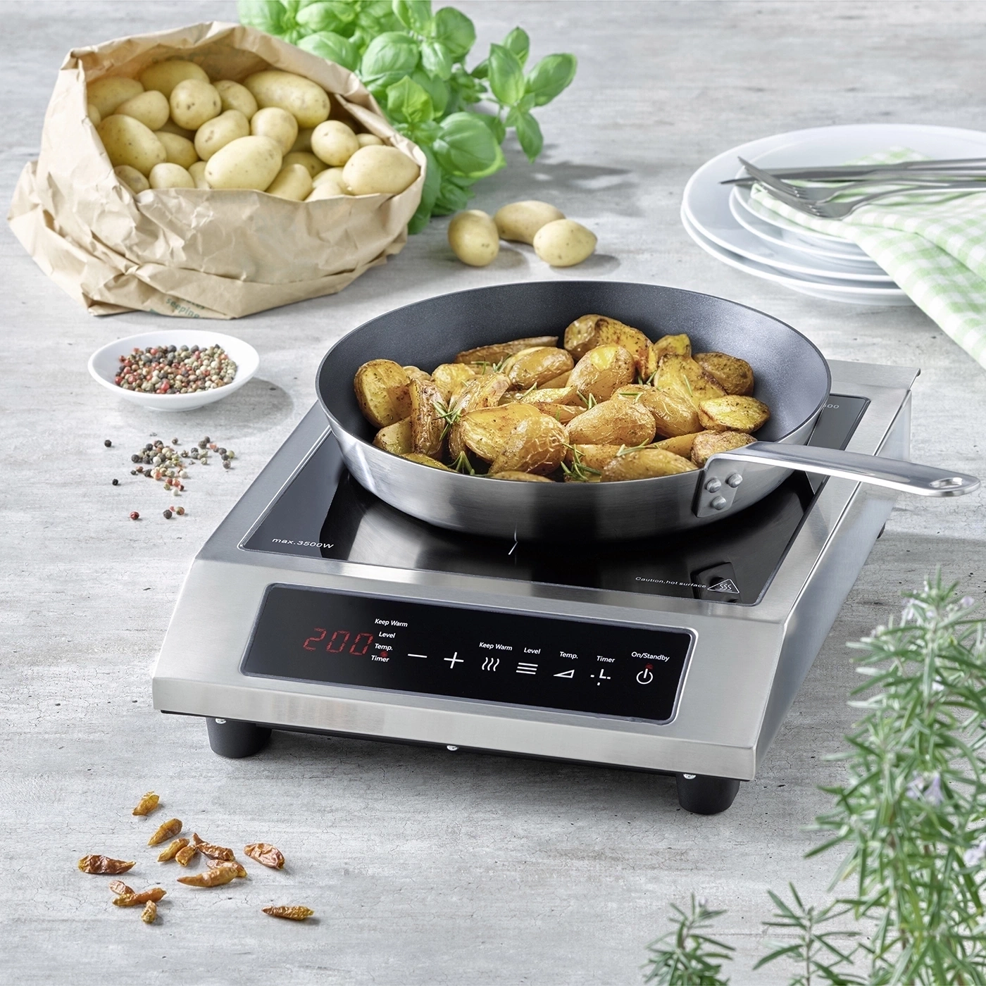 Fried potatoes on an induction hob with herbs and spices