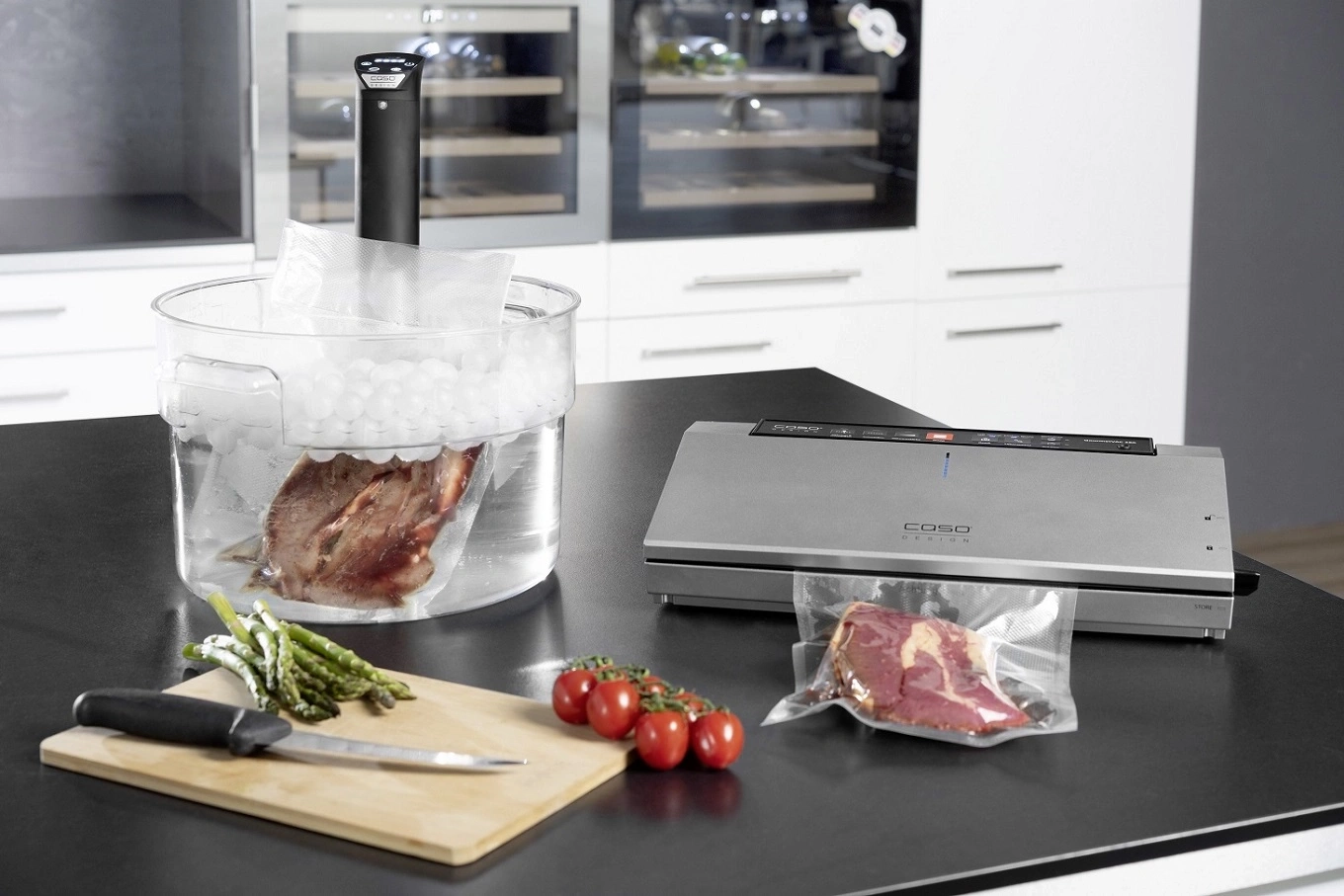 Sous-vide-Gerät mit Fleisch und Gemüse in der Küche