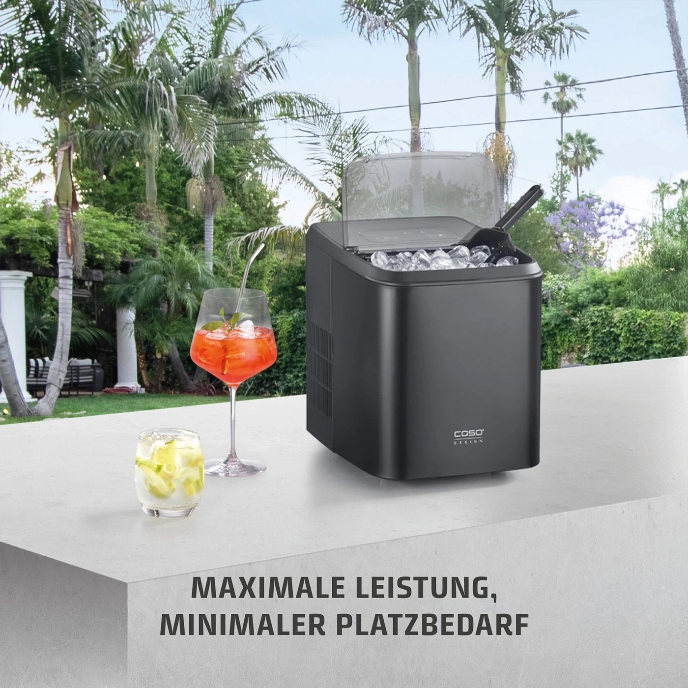 Eismaschine mit zwei Cocktails im Freien, Palmen im Hintergrund.