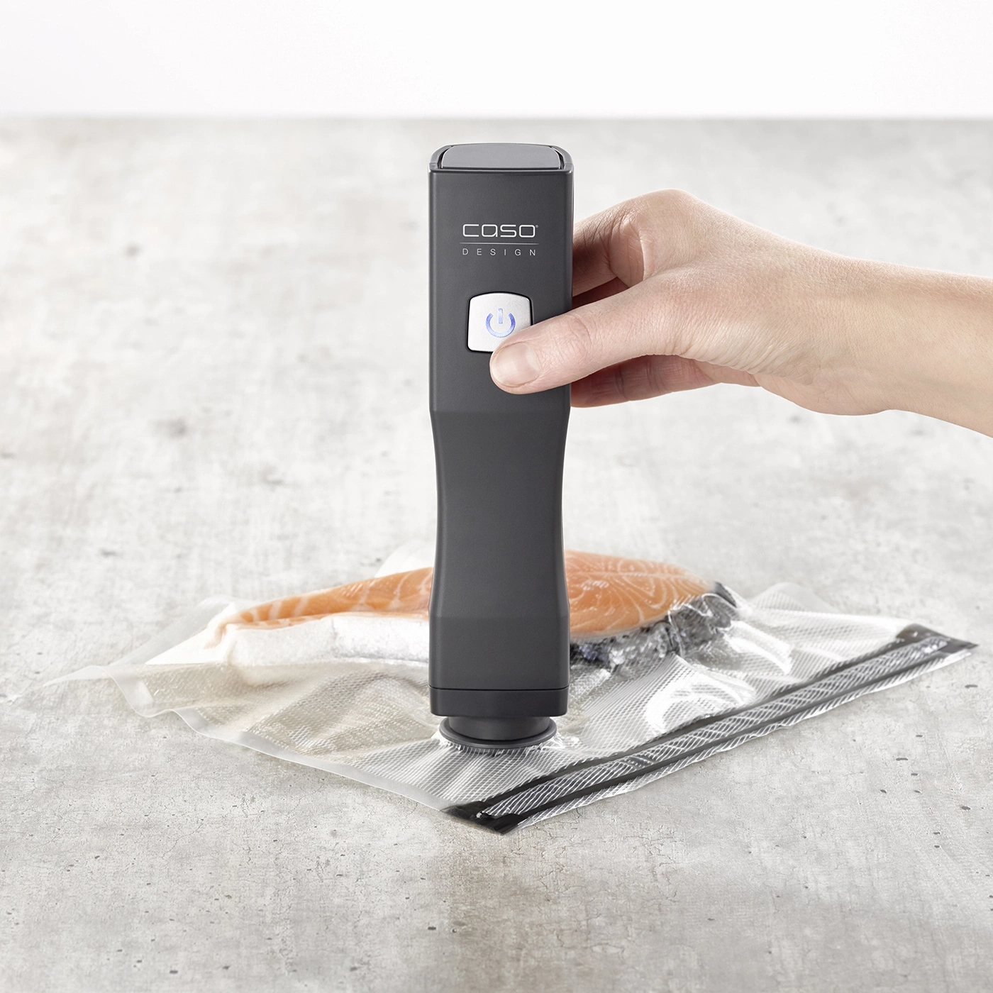 Ein Handheld-Vakuumierer versiegelt einen Lachs in einem Beutel.