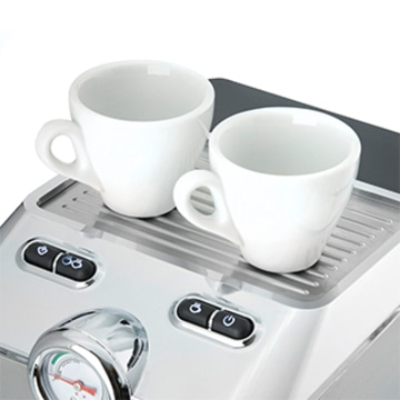 Nahaufnahme einer Espressomaschine mit zwei weißen Tassen auf der Oberseite.