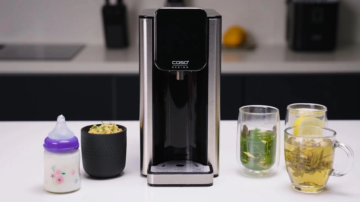 Wasserkocher mit Getränken, Babyflasche und Essen auf dem Tisch