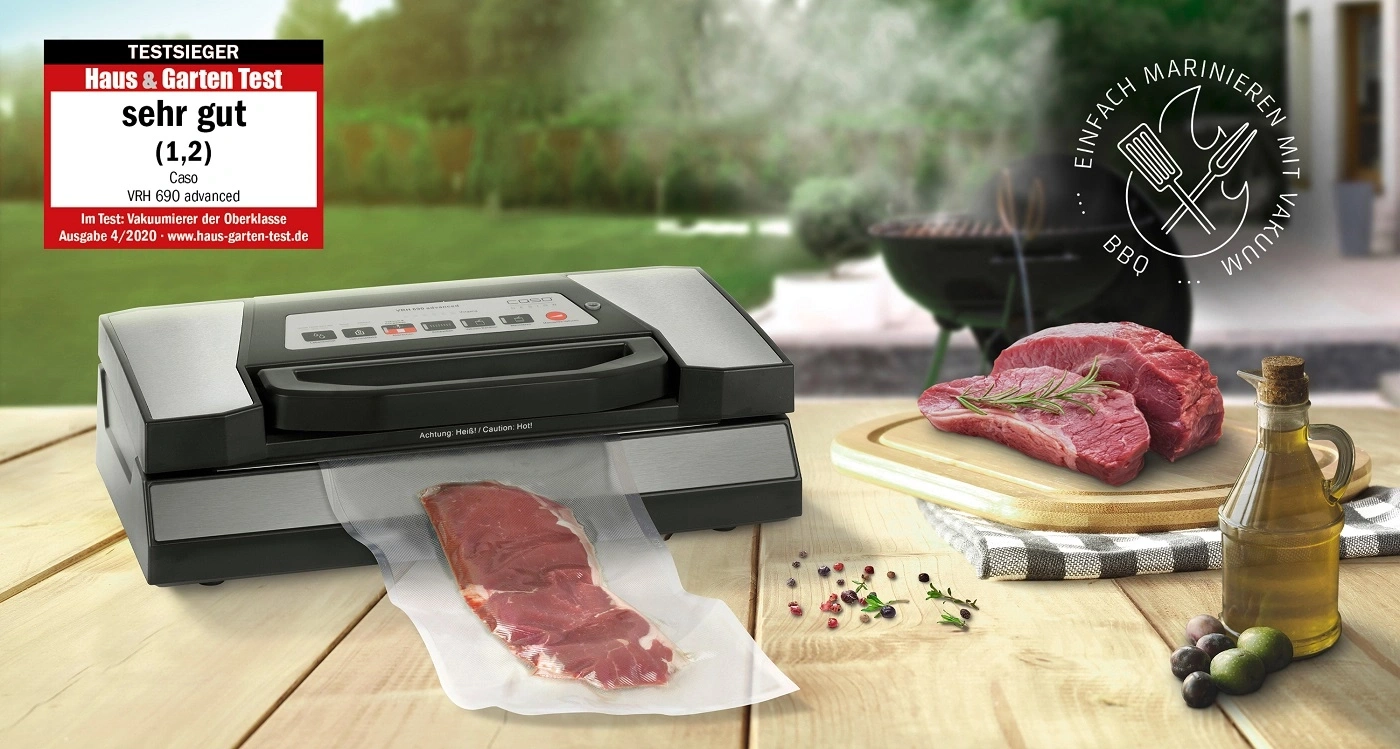 Vakuumiergerät mit Fleisch und Grill im Hintergrund