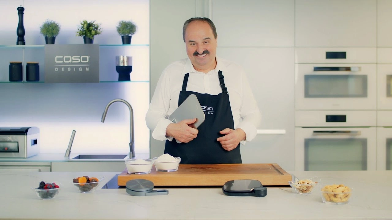 Man in kitchen with ingredients and scales, ready to cook.