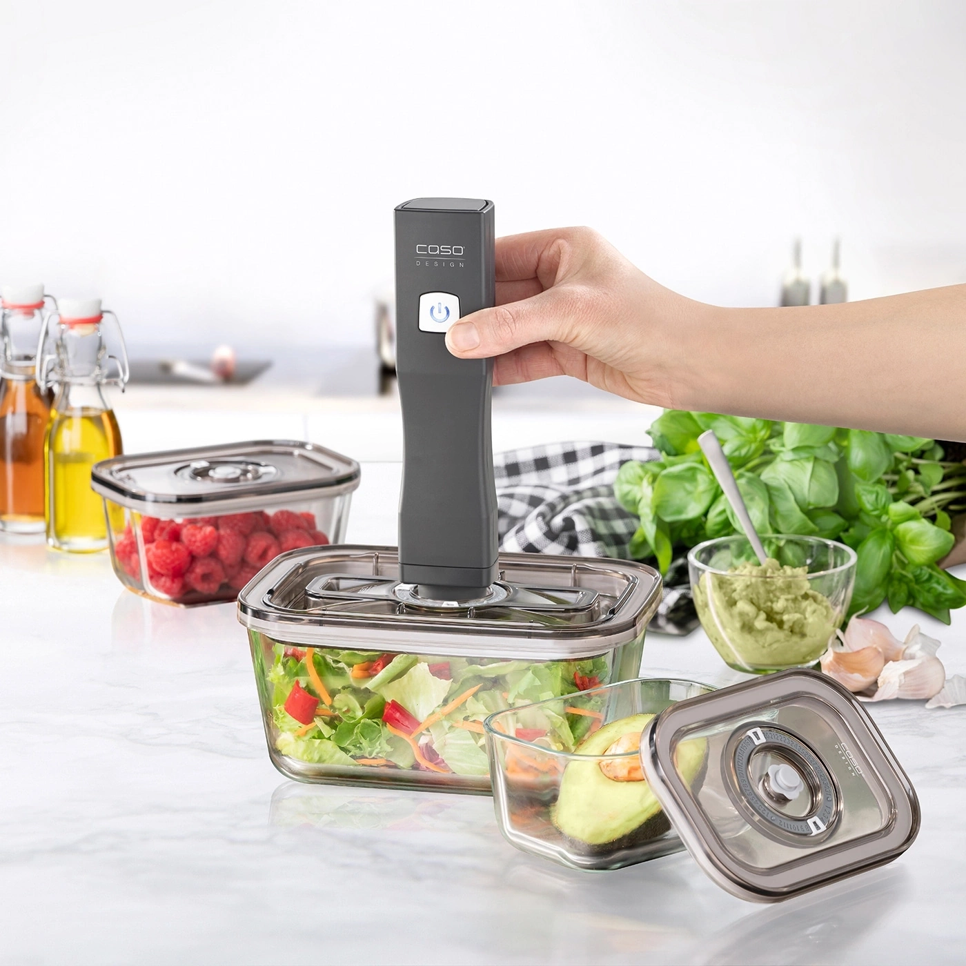 Vacuum sealer with containers, vegetables, fruits and avocado on marble table