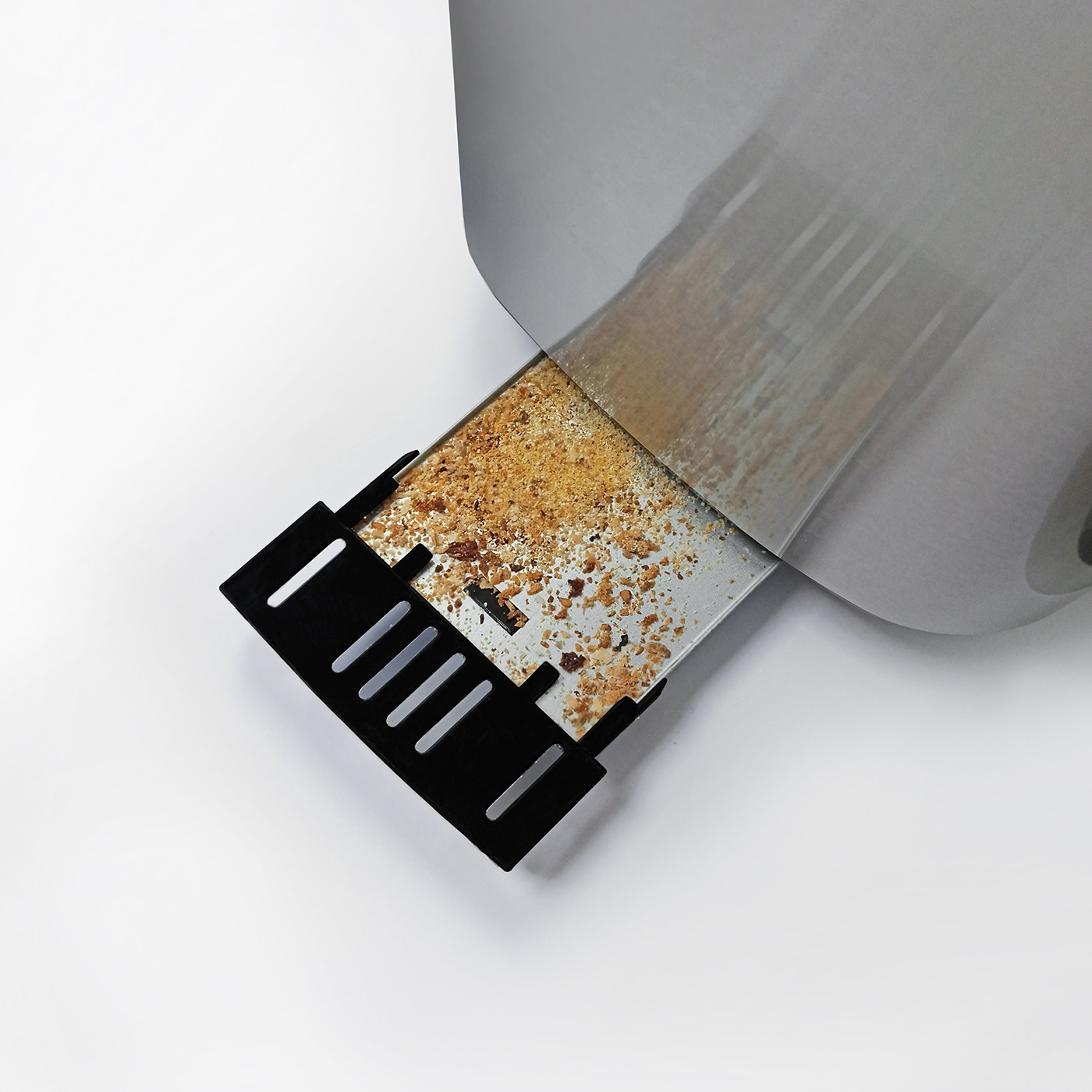 Nahaufnahme eines Toasters mit Krümeln und einem schwarzen Auffangbehälter.