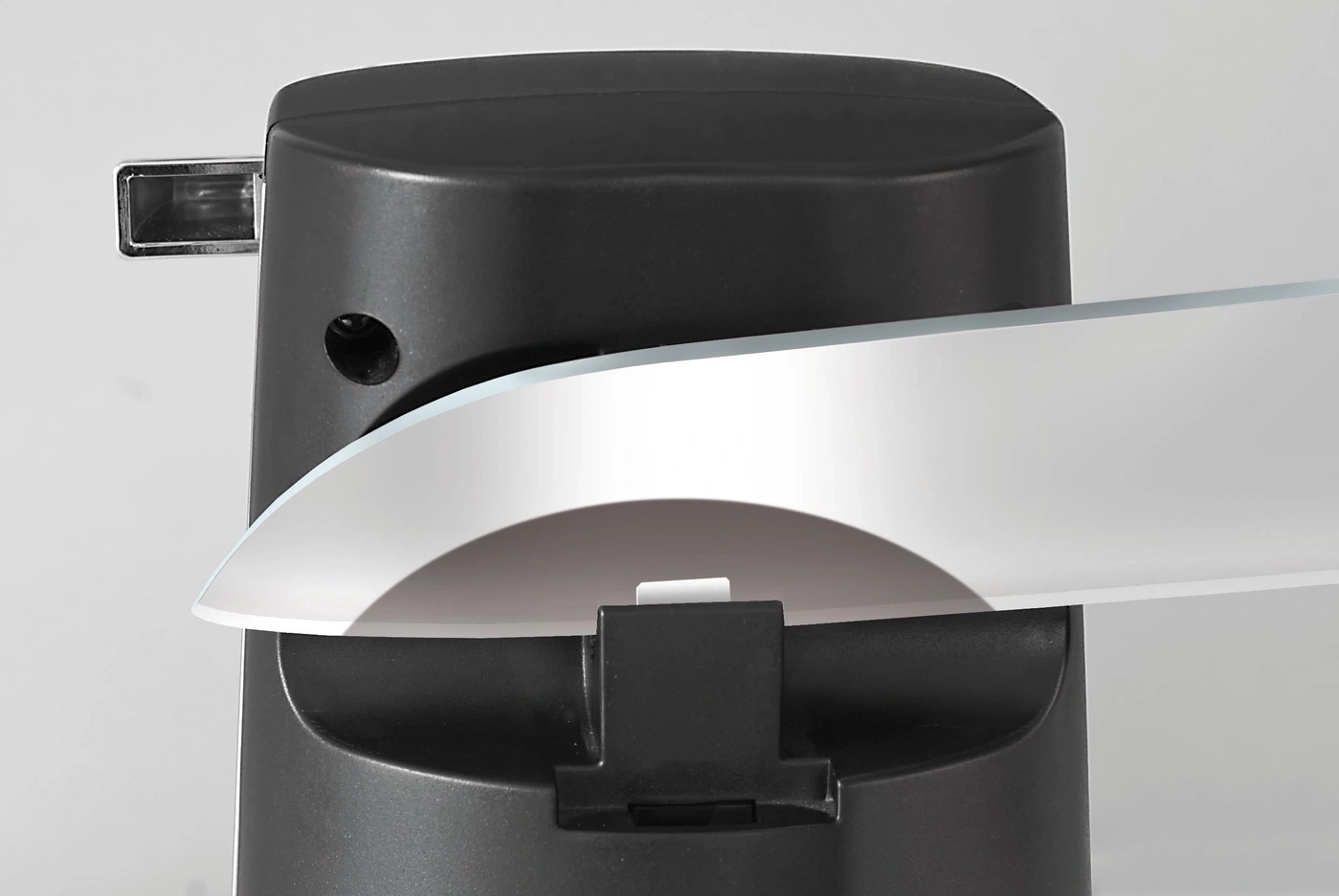 Gros plan d'un objet noir avec un élément blanc au-dessus, avec un fond clair