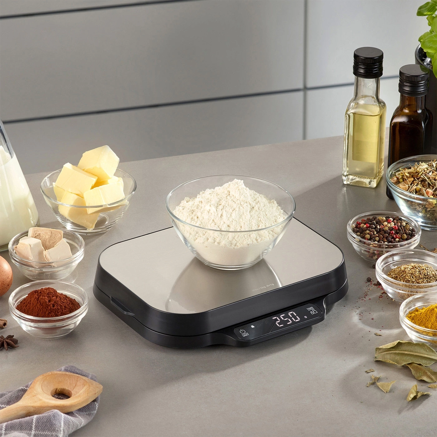 Küchenwaage mit Zutaten für Backwaren, Mehl, Butter, Gewürze, Öl.