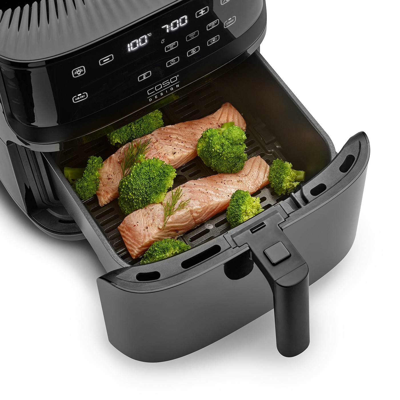 Air fryer with salmon and broccoli, ready for cooking.