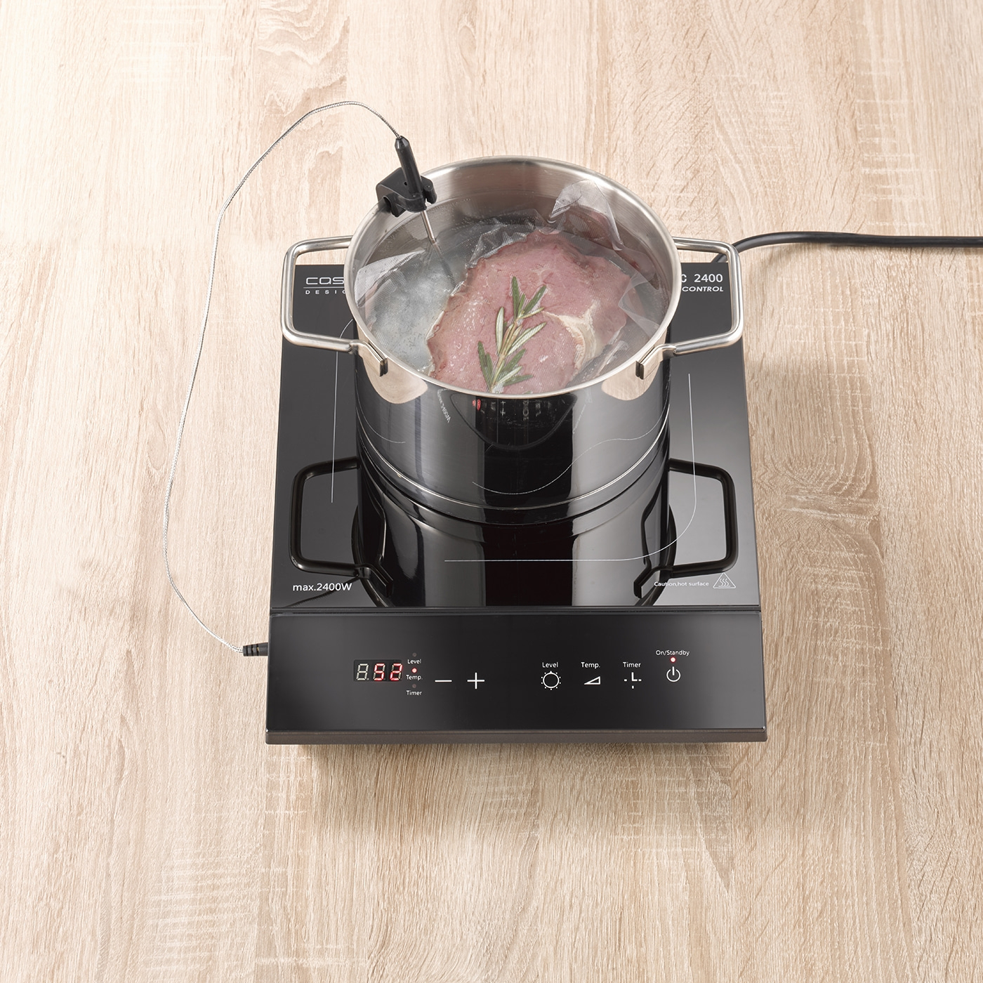 Topf mit Fleisch auf einem Kochfeld. Das Fleisch wird sous vide gegart.