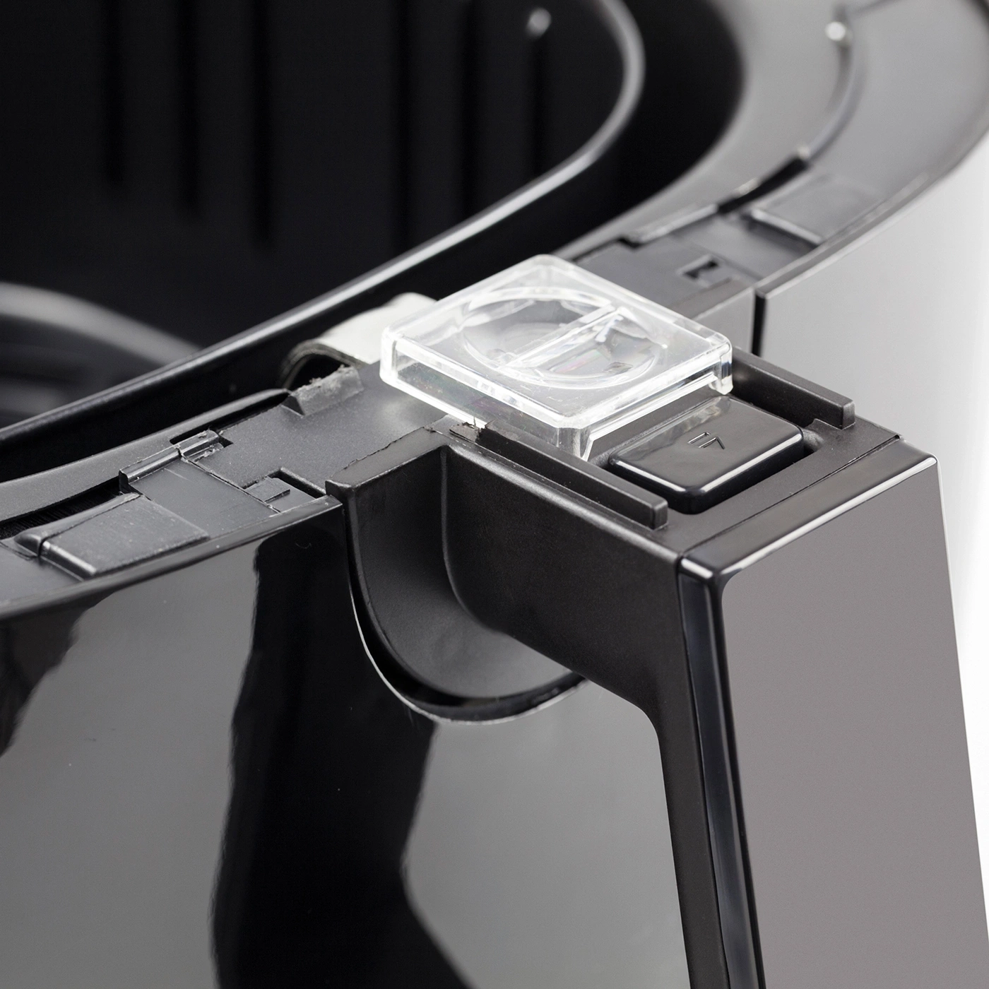 Nahaufnahme eines schwarzen Airfryers mit transparentem Verriegelungsmechanismus.