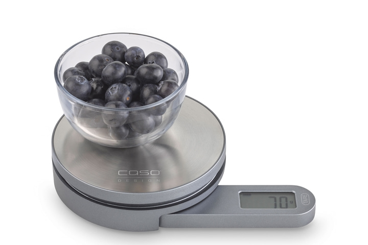 Blaubeeren in einer Glasschüssel auf einer Küchenwaage mit Anzeige von 70 g