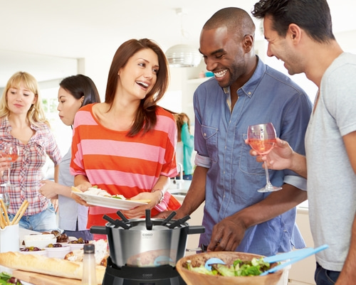 Freunde feiern zusammen mit Essen und Getränken. Fröhliche Stimmung.