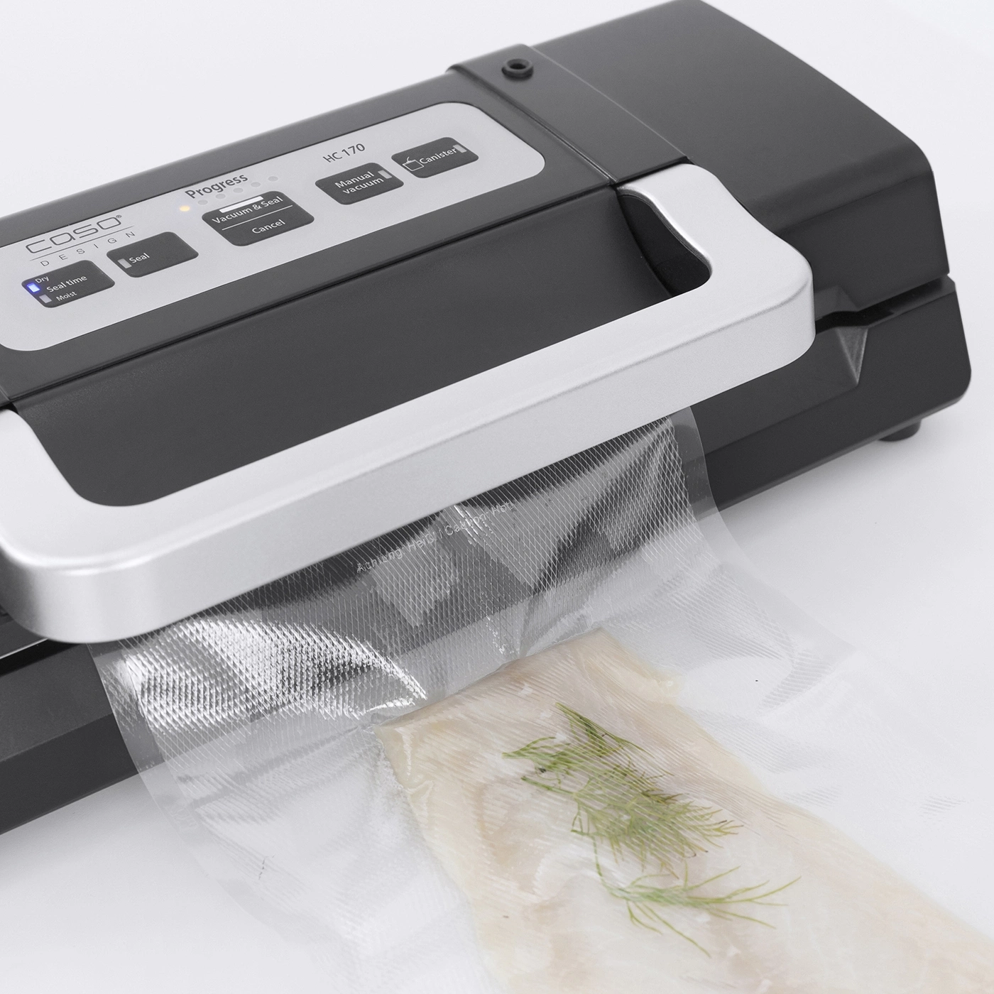 Ein Vakuumiergerät versiegelt Fisch mit Dill in einem Plastikbeutel.