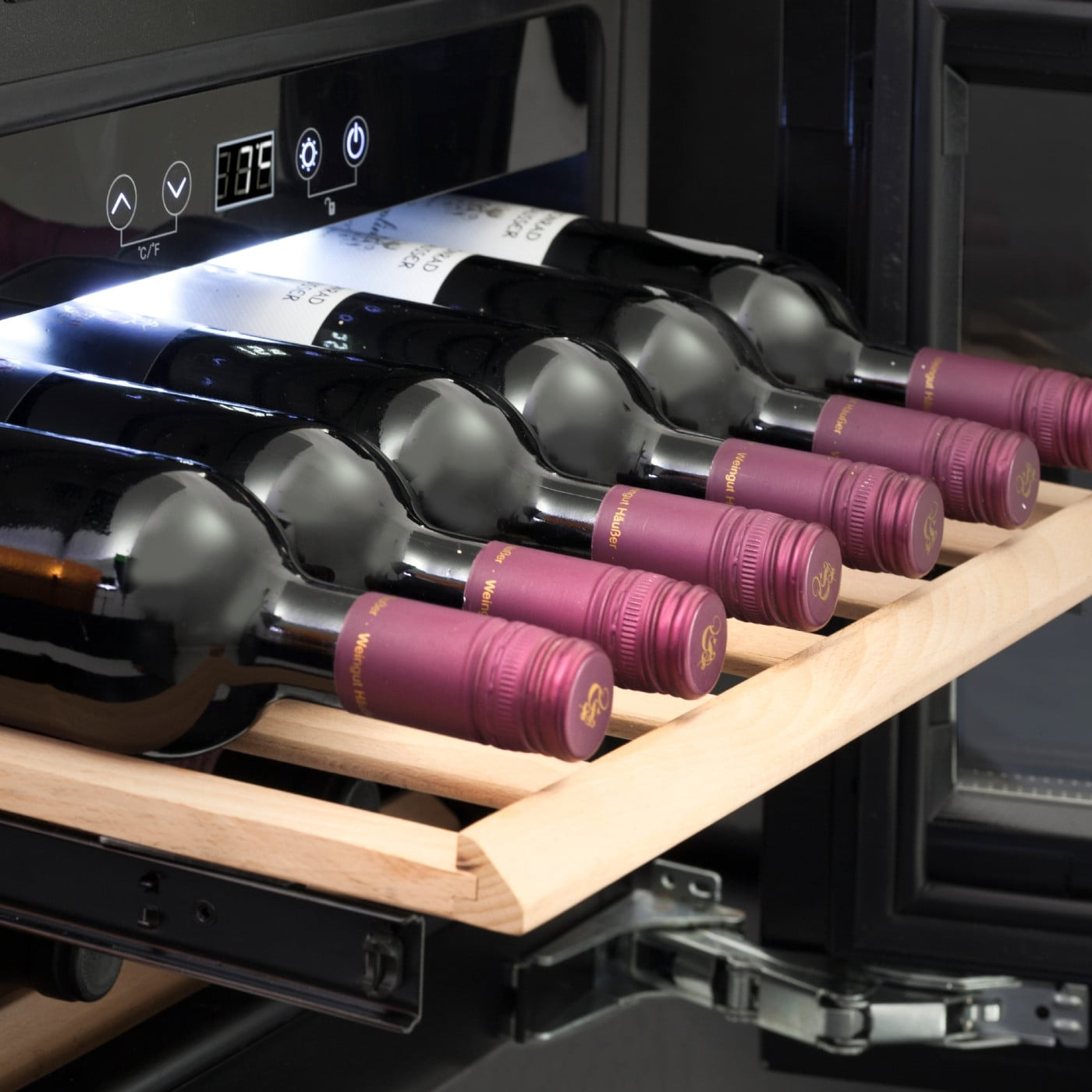 Wine cooler with wine bottles, temperature display, and wooden shelf.