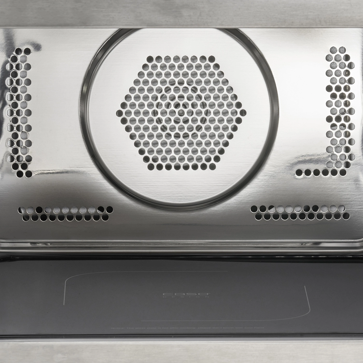 Close-up of microwave interior with metal grill and plate, modern design.
