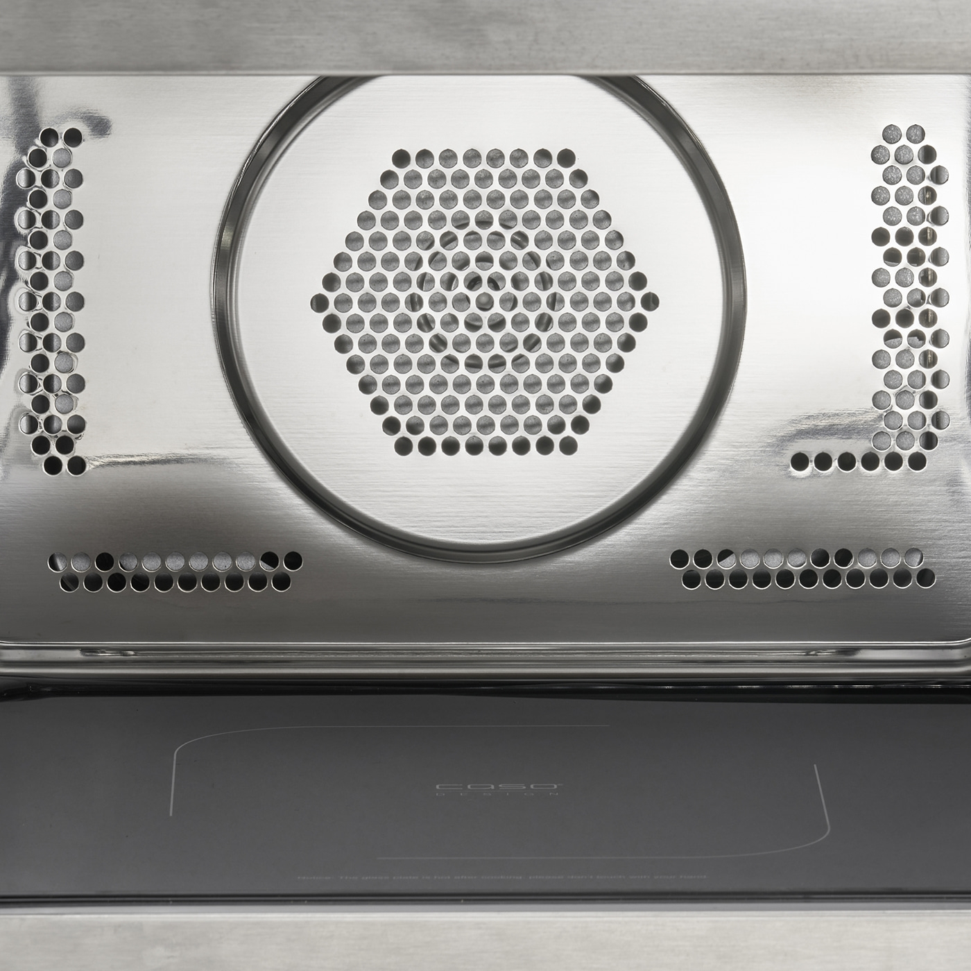 Close-up of microwave interior with metal grill and plate, modern design.