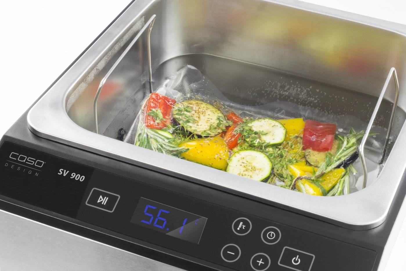 Sous vide cooker with vegetables bag and temperature display. Cooking in a water bath.