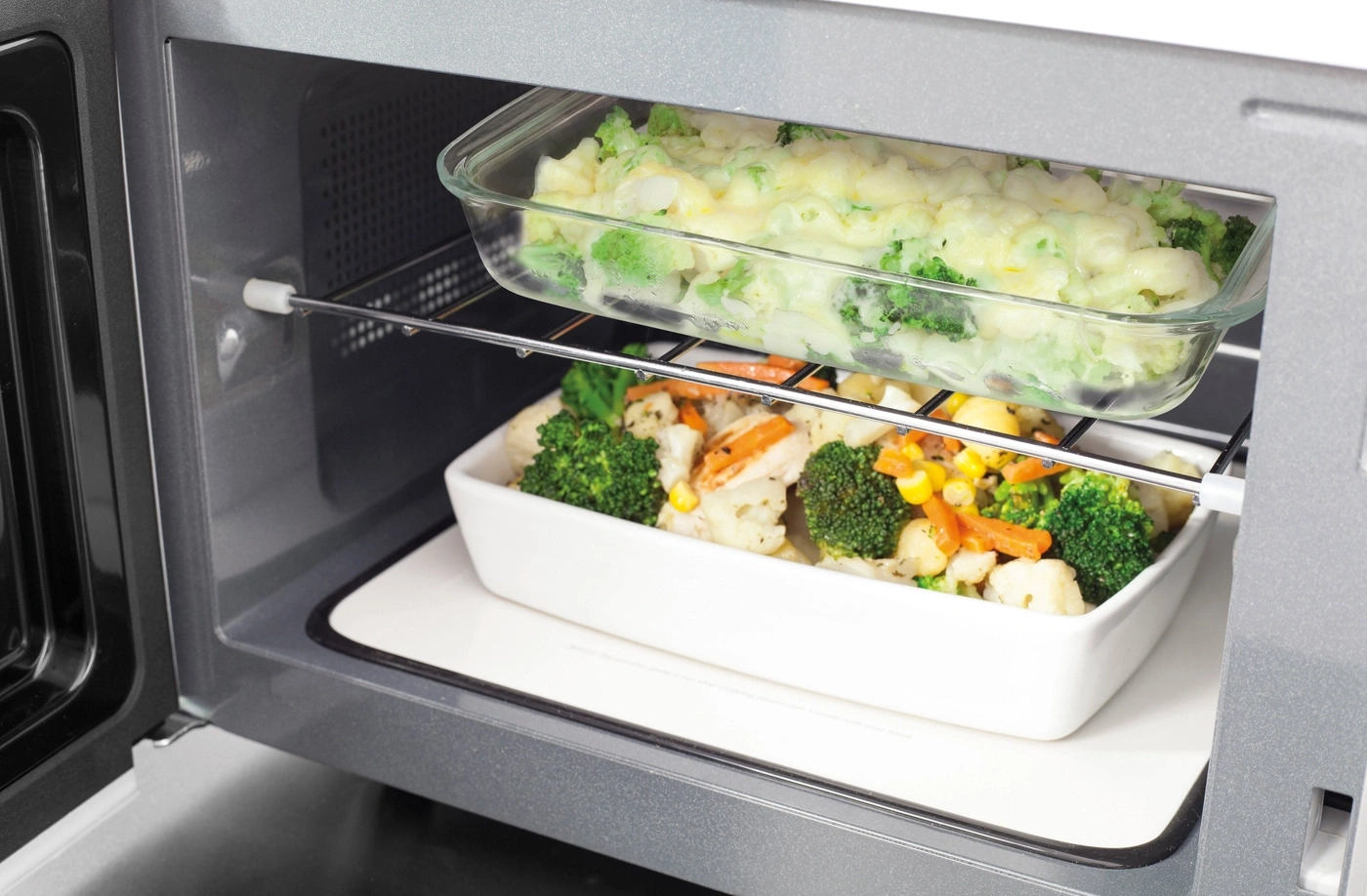 Micro-ondes avec plats de légumes prêts à cuire, gros plan de l'intérieur