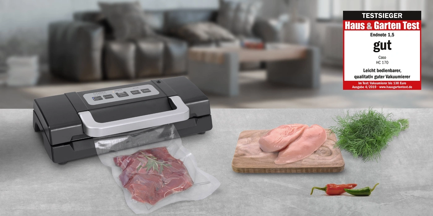 Vakuumiergerät mit Fleisch und Hühnchen auf einem Tisch