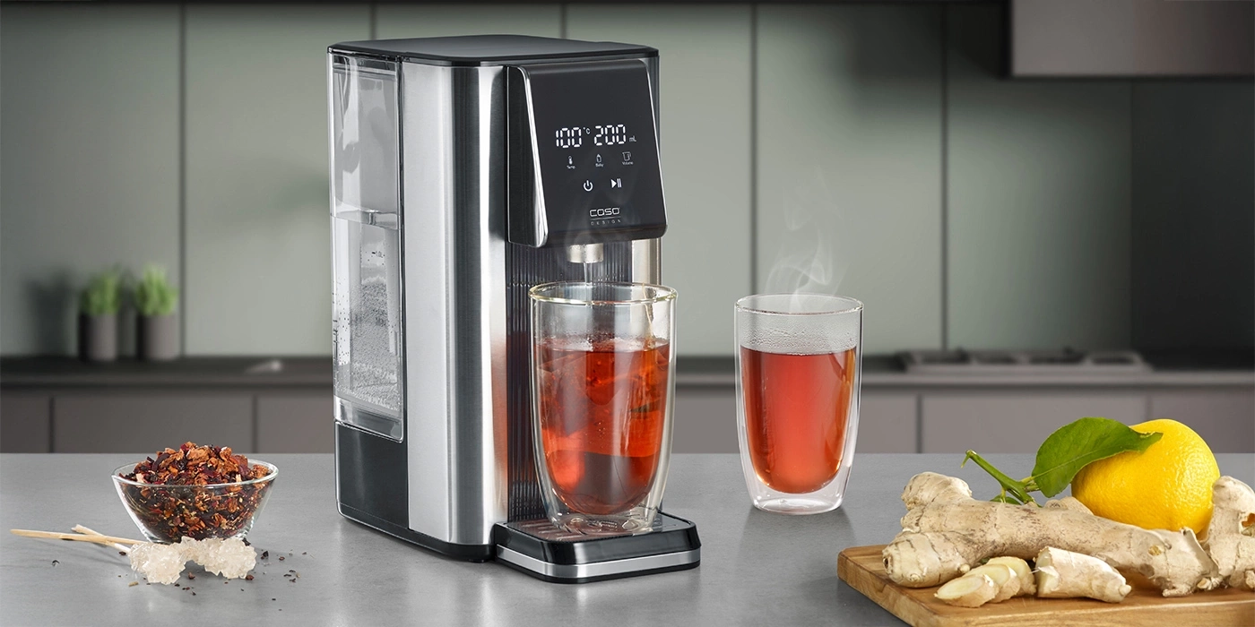 A water dispenser with two glasses of tea, ginger, and lemon.