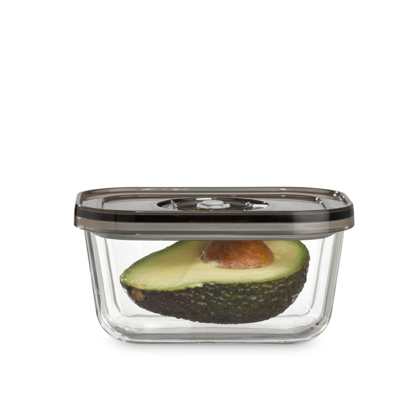 Avocado half in a glass container with lid, isolated on white background.
