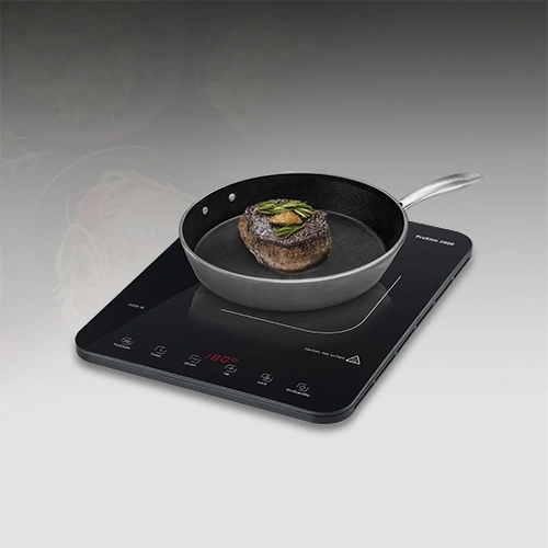 Un steak est saisi dans une poêle sur une plaque à induction.