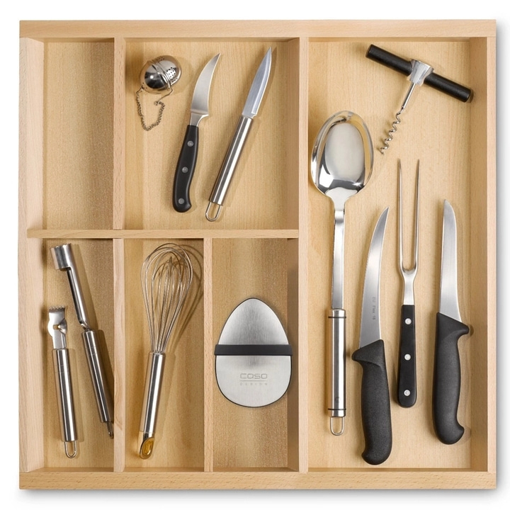 Küchenutensilien in einer Schublade: Messer, Löffel, Schneebesen, Korkenzieher.