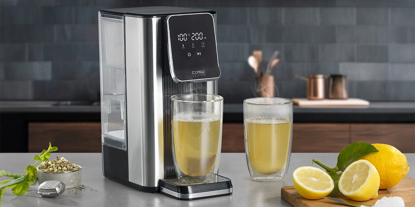 Hot beverage dispenser with two glasses of tea and lemons