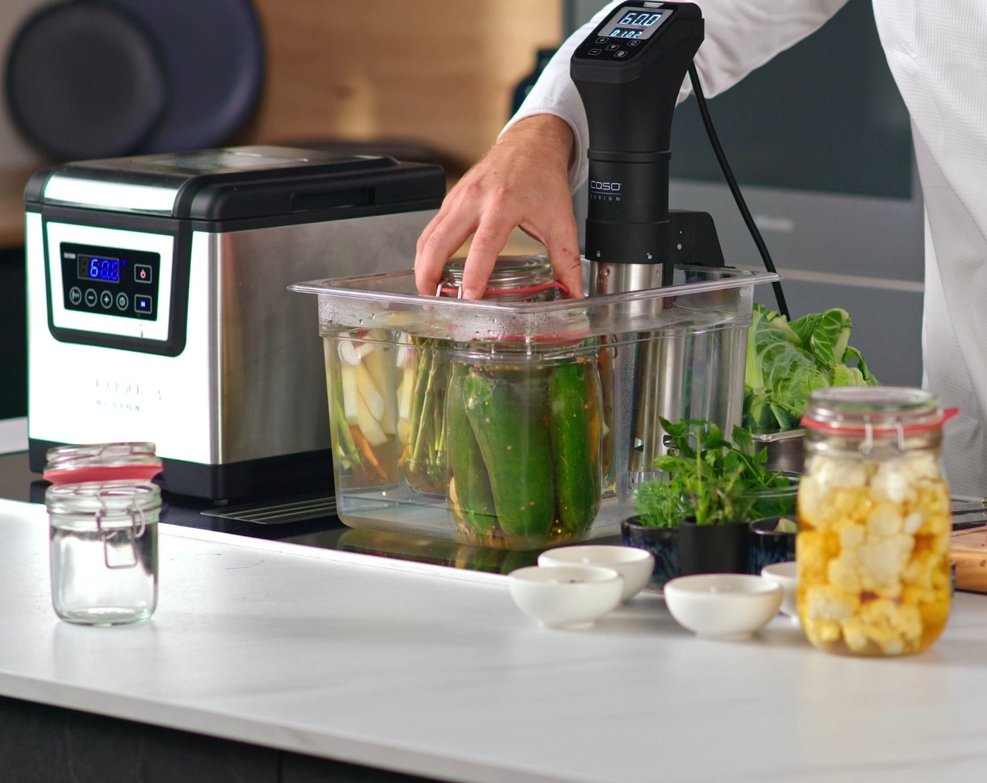 Ein Sous-Vide-Gerät mit Gläsern mit eingelegtem Gemüse und Blumenkohl.